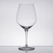 A Spiegelau Authentis burgundy wine glass on a table with a reflection.