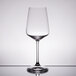 A Spiegelau white wine glass on a reflective surface.