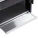 A metal tray with a black handle on a metal shelf.