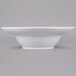 An American Metalcraft white stoneware bowl with a small rim on a gray background.