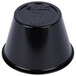 A close-up of a Solo black plastic souffle cup with a lid on top.