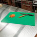 A Tablecraft flexible cutting board with a knife and carrots on it.