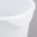 A close-up of a white Rubbermaid food storage bucket with a lid.