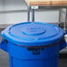 A blue plastic lid for a Rubbermaid BRUTE 55 gallon round trash can.