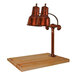 A Hanson Heat Lamps smoked copper carving station with maple block and gravy lane on a wooden surface with two copper lamps.