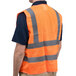 A person wearing a Cordova Orange high visibility safety vest with reflective stripes.