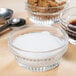 A group of silver bowls filled with Domino Pure Cane Extra Fine Granulated Sugar, brown sugar, and syrup.