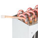 A close-up of a copper condenser coil with copper pipes.