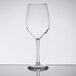 A Libbey customizable tall wine glass with a stem on a reflective surface.
