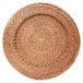 A close up of a brown woven rattan charger plate with a circular design.