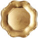 A white background with a  gold baroque charger plate with scalloped edges.