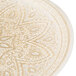 A close up of a gold glass Charge It by Jay charger plate with intricate designs.