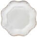 A white Charge It by Jay plastic charger plate with a decorative gold trim.