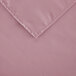 A pink square polyester cloth table cover with a hemmed edge.