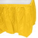A yellow plastic table skirt with a white background.