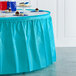 A table with a Bermuda Blue plastic table skirt on it.