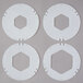 Four white plastic circular objects with holes in them.