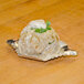 A Royal Paper aluminum foil crab shell filled with food on a tray.