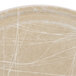 A close up of a Cambro round tan fiberglass tray with white abstract lines.