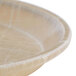 A beige Cambro round tray with a white abstract design.