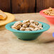 A bowl of nuts in a GET Rainforest Green Melamine Bowl on a table.