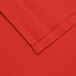 A close up of a red hemmed square table cover corner.