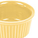 A yellow fluted ramekin with a white rim.