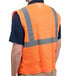 A person wearing a Cordova orange high visibility safety vest with reflective stripes.