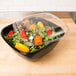 A salad in a Sabert black plastic catering bowl.