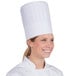 A woman wearing a Royal Paper pleated disposable chef hat.