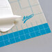 An Ateco non-stick silicone baking mat with grid measurements on a blue mat.