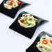 A group of black Fineline Tiny Temptations trays with vegetables on them.