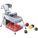 An Edlund electric vegetable slicer with two 3/16" blades slicing tomatoes.