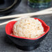 A white GET Fuji melamine bowl filled with rice on a table with chopsticks.