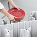 A person using a Cambro dish caddy to hold a stack of plates.