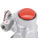 A close up of a silver gas safety valve with a red button.