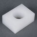 A white plastic square with a hole in it.