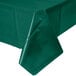 A folded hunter green plastic tablecloth on a table.