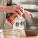 A person sprays Bak-Klene bread pan release into a baking dish.