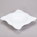 A white square melamine bowl with a circular pattern on the bottom.