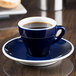 A close-up of a blue CAC Venice espresso cup on a saucer.