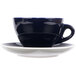 A blue CAC Venice coffee cup and saucer on a black and white saucer.