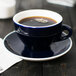 A CAC Venice blue cup of coffee on a saucer.