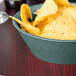 An HS Inc. jalapeno basket filled with chips on a table in a Mexican restaurant.