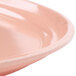A close up of a dark peach Cambro oval tray with a rim.