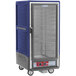 A blue and silver Metro C5 heated holding cabinet on wheels with a clear door.