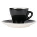 A CAC black and white espresso cup and saucer on a white surface.