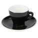 A black CAC Venice espresso cup and saucer on a white plate.