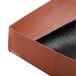 A close up of a brown box with black lining with a black strip.