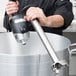 A person using a Waring stainless steel shaft on a hand blender.